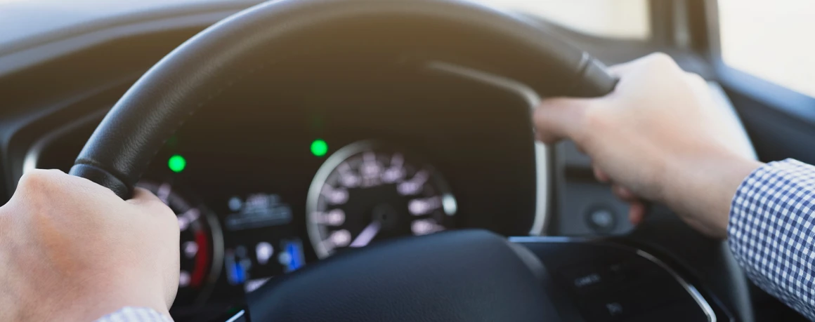 Person holding a steering wheel that is vibrating from flat-spotting.
