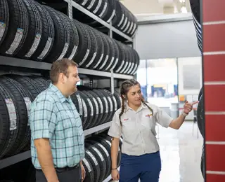 Les Schwab employee showing a customer different tire brands