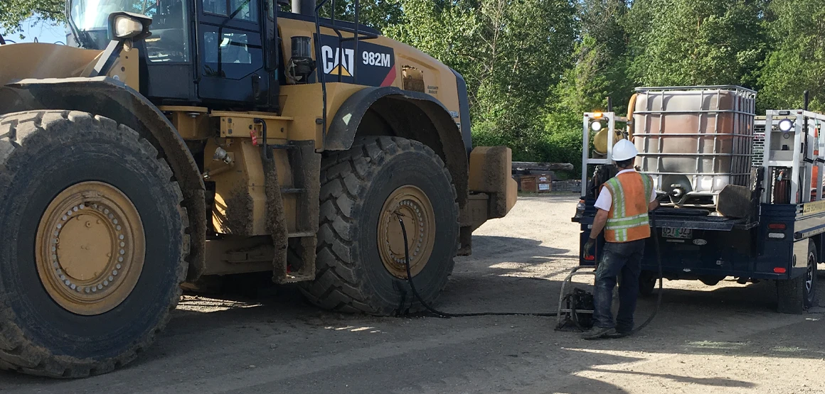 Les Schwab employee adding air to construction tire