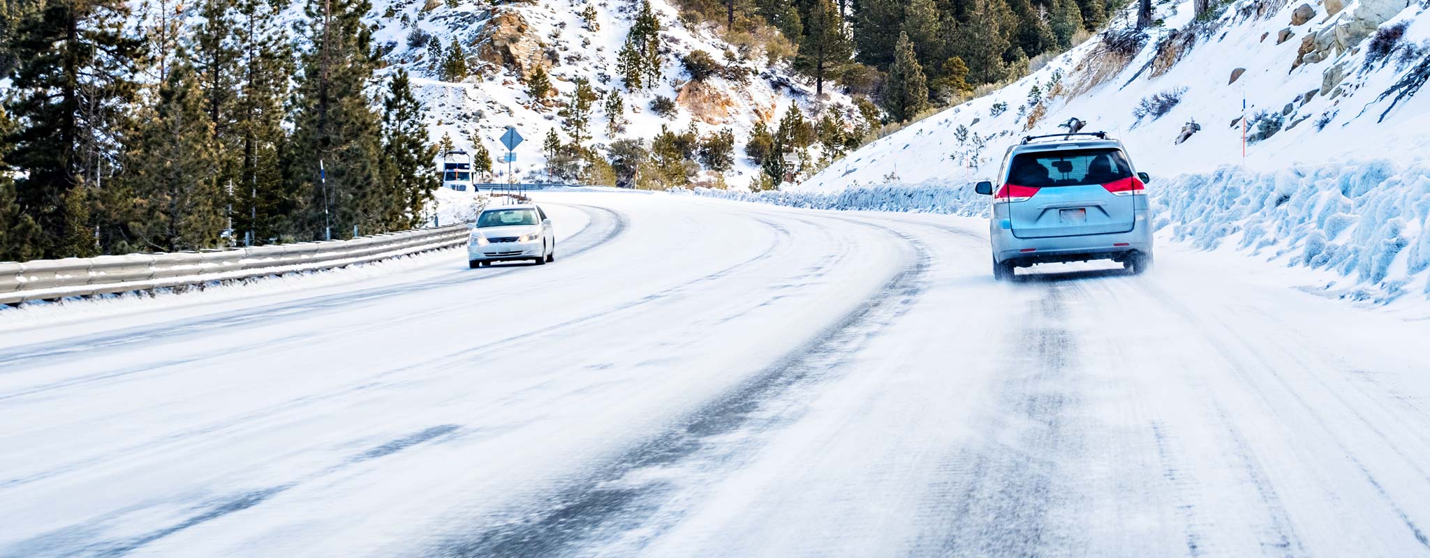 Cars driving on icy winter road.