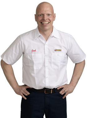 A Les Schwab technician stands arms akimbo. His name is Joshua