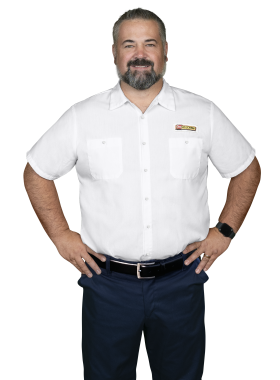 A Les Schwab technician stands arms akimbo. His name is Doug