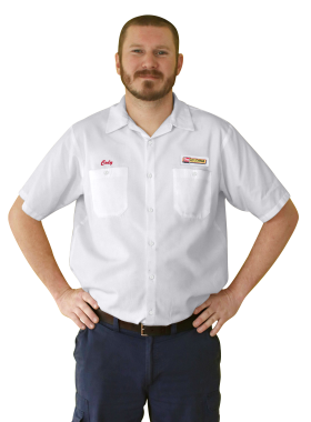 A Les Schwab technician stands arms akimbo. His name is Cody